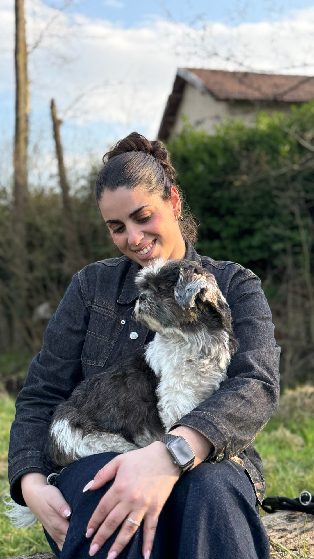 Lia, fondatrice du domaine, souriante avec un petit chien dans les bras